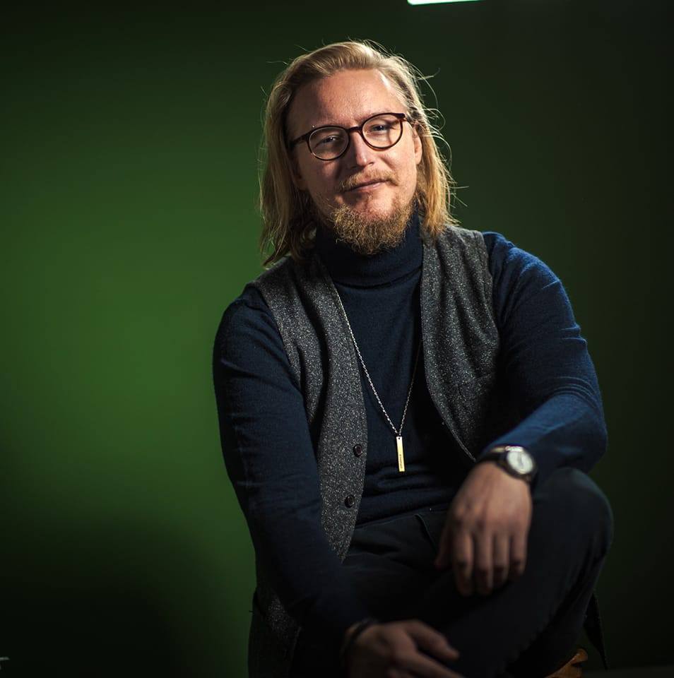 Photo of myself sitting in a chair in a green room